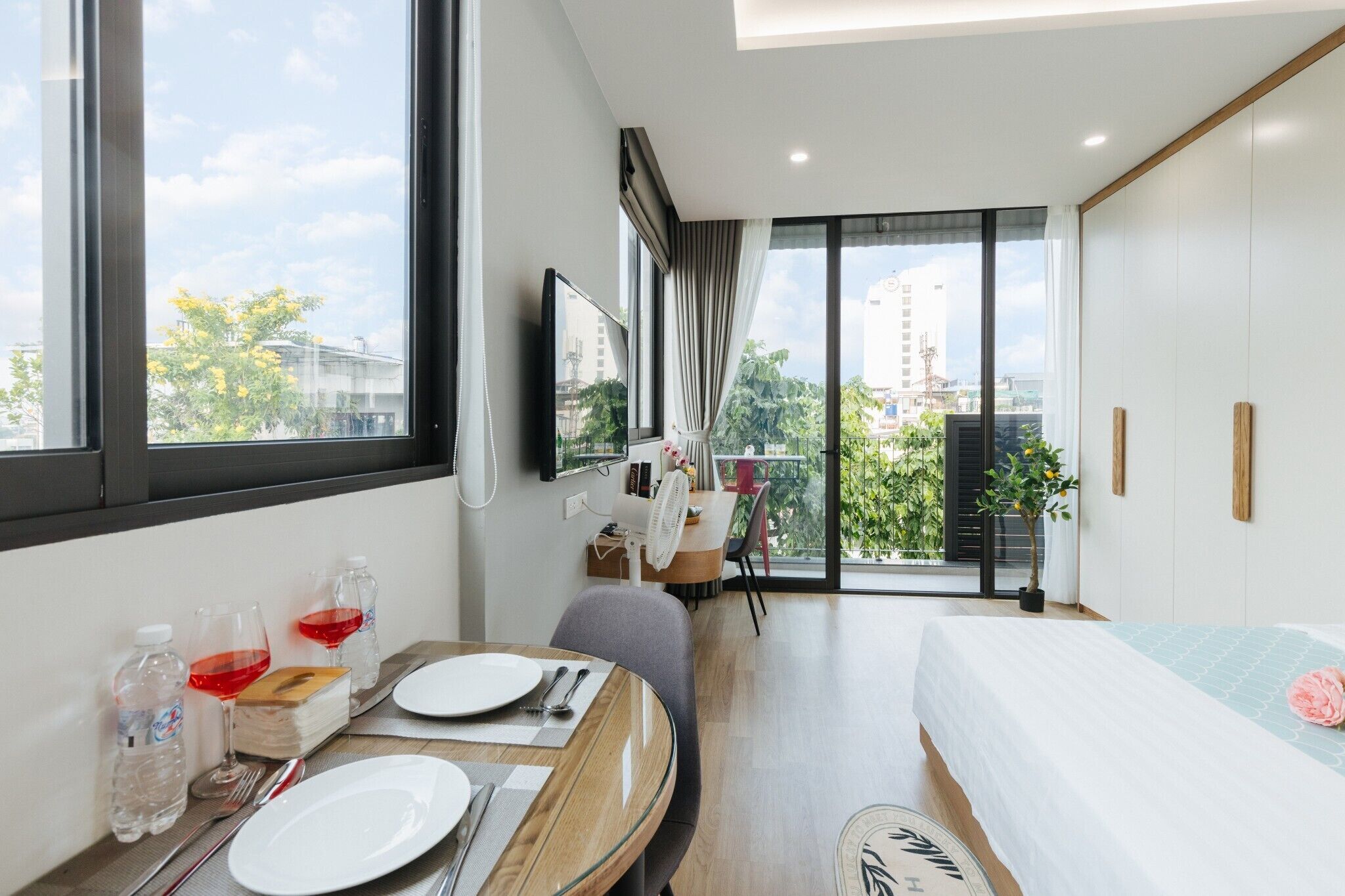 Une chambre d’hôtel moderne dotée d’un coin repas, d’un lit et d’un balcon offrant une vue sur la ville.