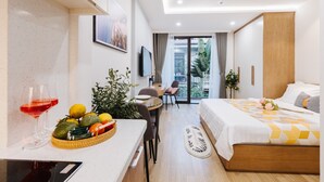 A modern hotel room with a bed, a dining area, and a view of the outdoors. - Margaery Boutique Apartment (Hanoi)