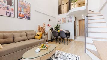 A modern living room with a sofa, coffee table, and dining area.