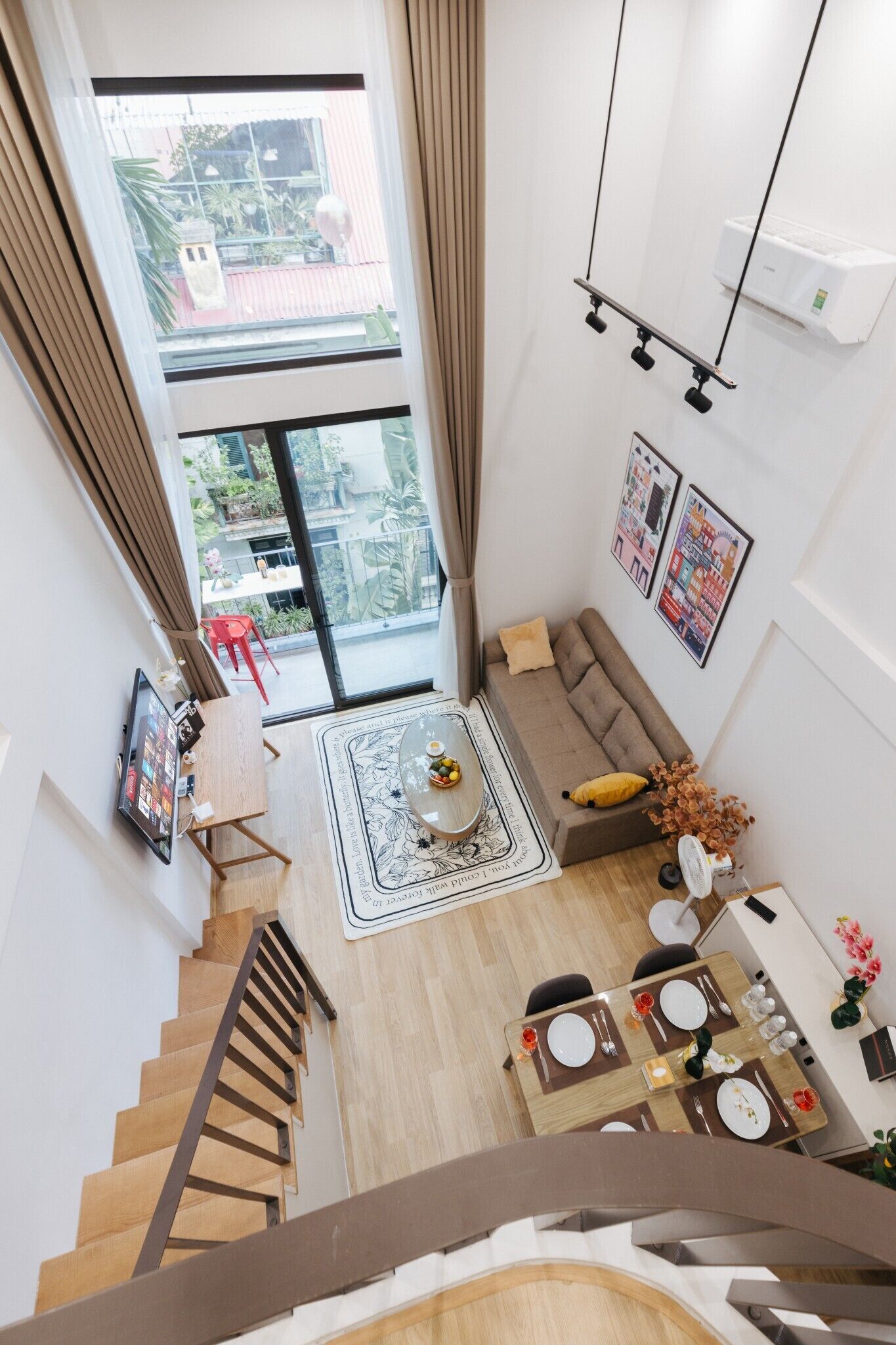 Ein zeitgemäßer Wohnraum mit Essbereich, einer Couch und einer Treppe.