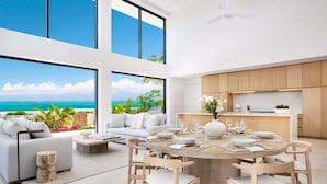 Un intérieur moderne comprenant un coin repas, une cuisine et de grandes fenêtres donnant sur une plage.