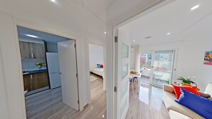 A modern apartment with a kitchen, dining area, and living room. - PREMIUM HABITAT LA RIERA (Pineda de Mar)