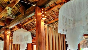 A room with two beds, wooden beams, and a thatched ceiling. - Resort Pù luông Boutique Garden (Pu Luong)