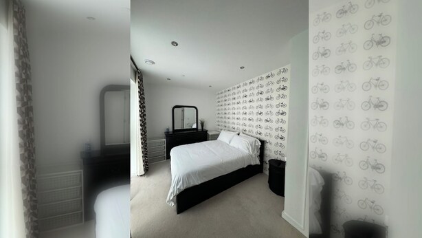A bedroom with a bed, a dresser, a mirror, and a wall with a bicycle pattern. - Spacious & Family Friendly | 3 Beds | Stratford (London)