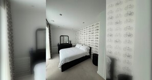 Une chambre à coucher comprenant un lit, une commode, un miroir et un mur décoré d’un motif représentant des vélos.