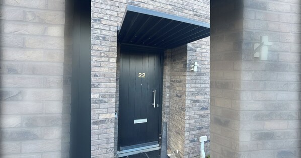 A black door with the number 22, a metal handle, and a small sign above the door.