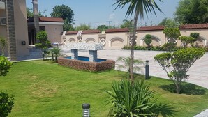 A courtyard with a swimming pool, palm trees, and a stone fountain. - Entire 6-bed Garden Villa (Chakswari)