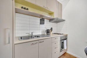 A modern kitchen with a double sink, stainless steel appliances, and a built-in oven.