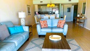 Un salon avec un canapé bleu, une table basse et un tapis à motifs.