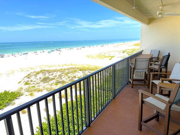 A balcony with a view of a beach and ocean.