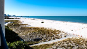 A beach with a clear sky, a long stretch of sand, and a distant pier. - Surfside 503 - 2 Bedroom 2 Bath Oceanfront Condo (Clearwater)