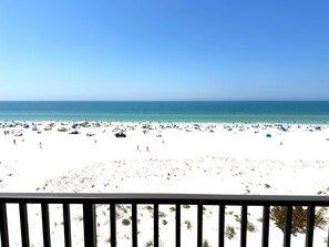 Une plage de sable blanc, avec une eau d’un bleu limpide et une vue sur l’océan.
