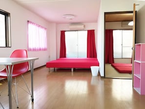Een kamer met een bed, bureau, stoel en kledingkast.