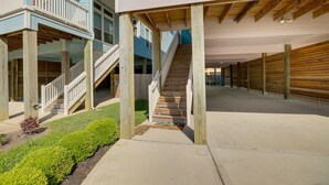 A multi-level wooden structure with a central staircase, surrounded by a concrete walkway and a small garden area. - Bay-View La Porte Home Rental: Steps to Beach! (La Porte)