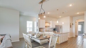 A spacious kitchen with white cabinets, a central island, and pendant lighting. - Bay-View La Porte Home Rental: Steps to Beach! (La Porte)