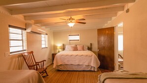 A bedroom with a bed, a chair, and a wooden door.