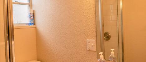 A bathroom with a toilet, sink, and shower.