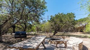 An outdoor picnic area with picnic tables and a barbecue grill. - Located 1/4 Mile to River Access (Concan)