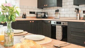 Une cuisine moderne avec des meubles de couleur sombre, un four à micro-ondes, un grille-pain et un lave-vaisselle.