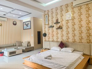 Habitación Deluxe | Zona de estar | Televisión de 14 pulgadas con canales por cable