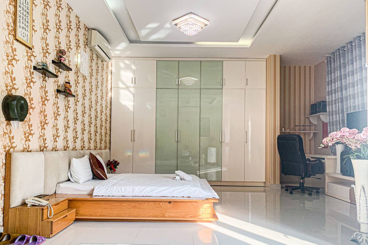 Une chambre à coucher moderne avec un lit, une table de chevet et une armoire.