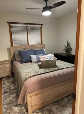 Restful retreat with a comfortable bed, ceiling fan, and natural light pouring in through the window.