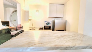 A compact kitchen with a sink, microwave, and refrigerator.