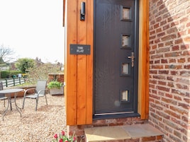 Una puerta de madera con un letrero que dice "THE FLAT" y una pequeña ventana.