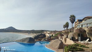 Ein Poolbereich mit Blick auf Strand und Berge.