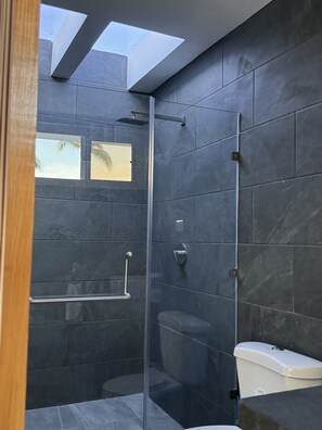 Een douche, handdoeken, zeep, toiletpapier