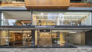 A modern building with a glass facade, a sign reading "Ambares SEIS CUATRO", and a visible entrance with a staircase. - Amberes 64, an Ascend Collection Hotel (Mexico City)