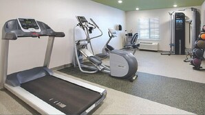 A gym with a treadmill, elliptical, and weight machines. - Woodspring Suites Rochester Greece (Rochester)