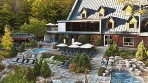 Un resort con piscina, sillas de descanso y una cascada.
