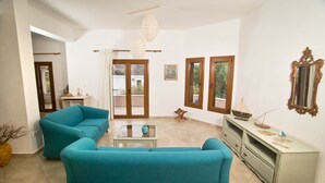 Una sala de estar con dos sofás, una mesa de centro y un mueble para televisor.