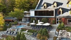 A resort with a pool area, lounge chairs, and a waterfall. - Le Cocoon 5 minutes from Mont Orford and Magog (Orford)
