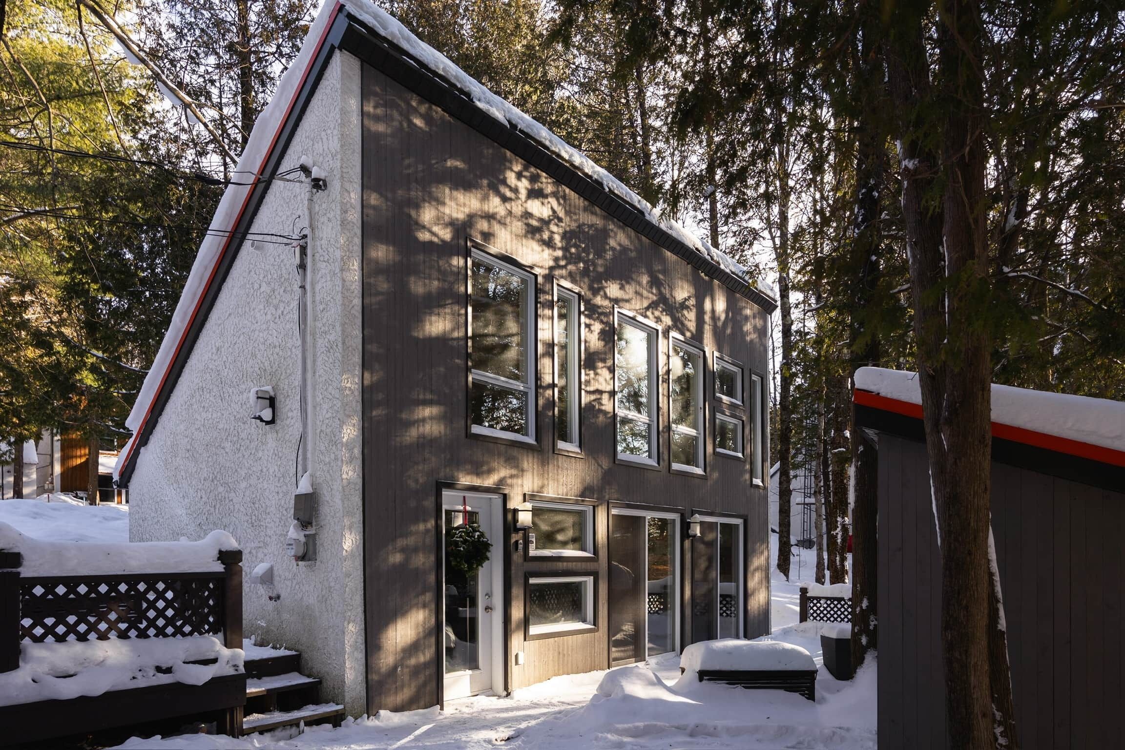 Un bâtiment à deux étages, doté de nombreuses fenêtres et dont le toit est recouvert de neige.