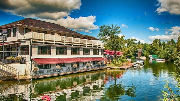 Un edificio junto al río con balcón y zona de estar al aire libre.