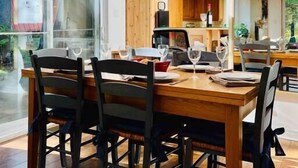 Un comedor con una mesa de madera, cuatro sillas y una lámpara colgante.
