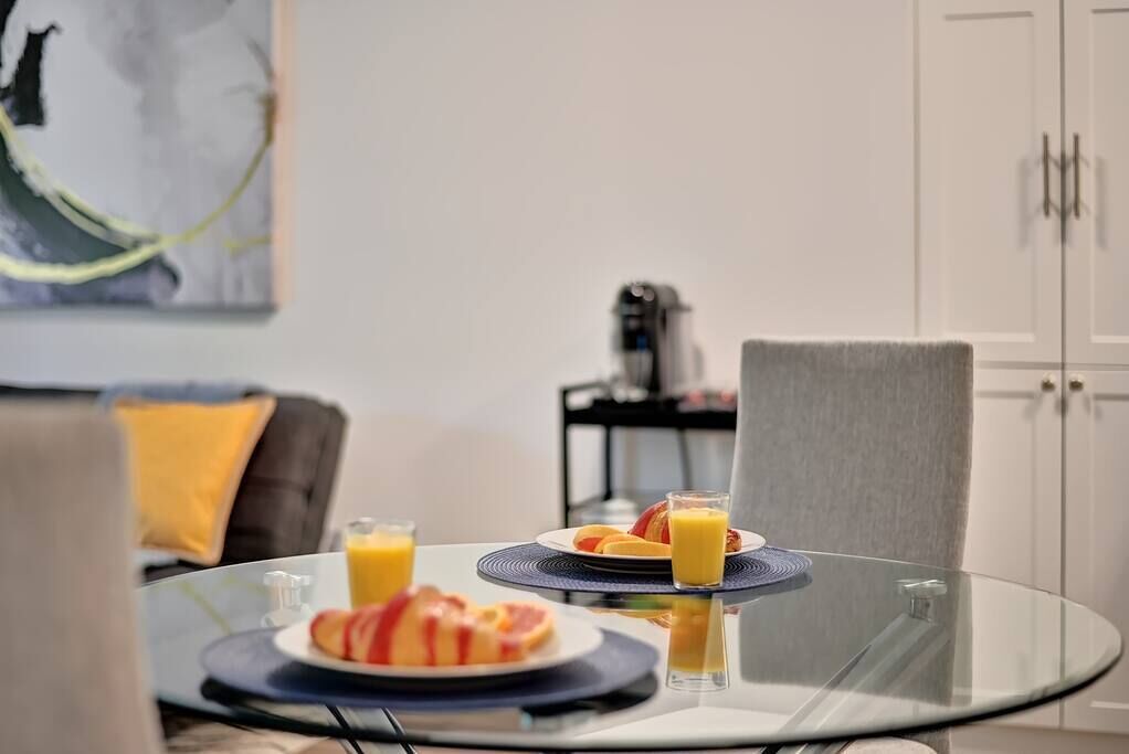 A dining table with plates of food and glasses of orange juice.