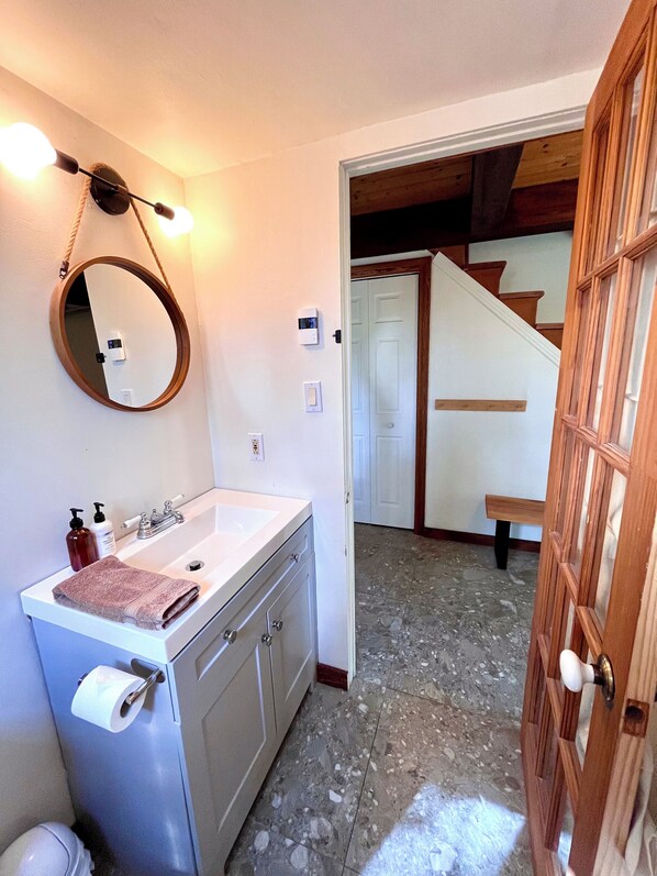 A bathroom with a sink, mirror, and towel.