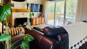 A cozy living room with a fireplace, a large window, and a comfortable seating area. - Le Refuge-Orford 6 PeopleSEPAQ (Orford)