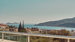 A coastal town with buildings overlooking a clear blue sea and hills in the distance. - Villa Nordic Dream (Kas)