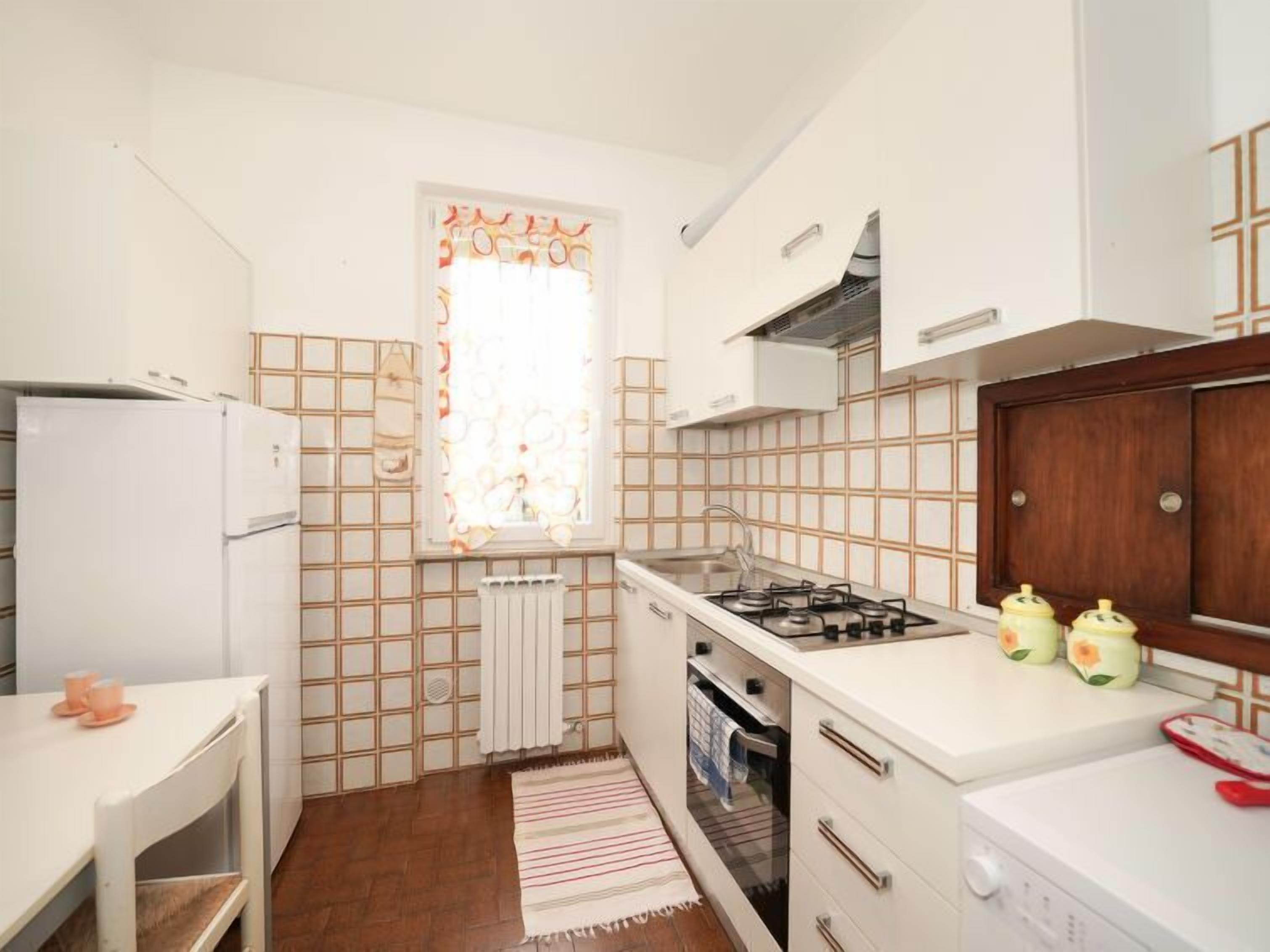 Eine kleine Küche mit Kühlschrank, Herd und Spüle.