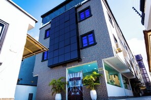 A modern building with a large glass facade, multiple windows, and a visible entrance. - 247 Luxury Apartment (Lekki)