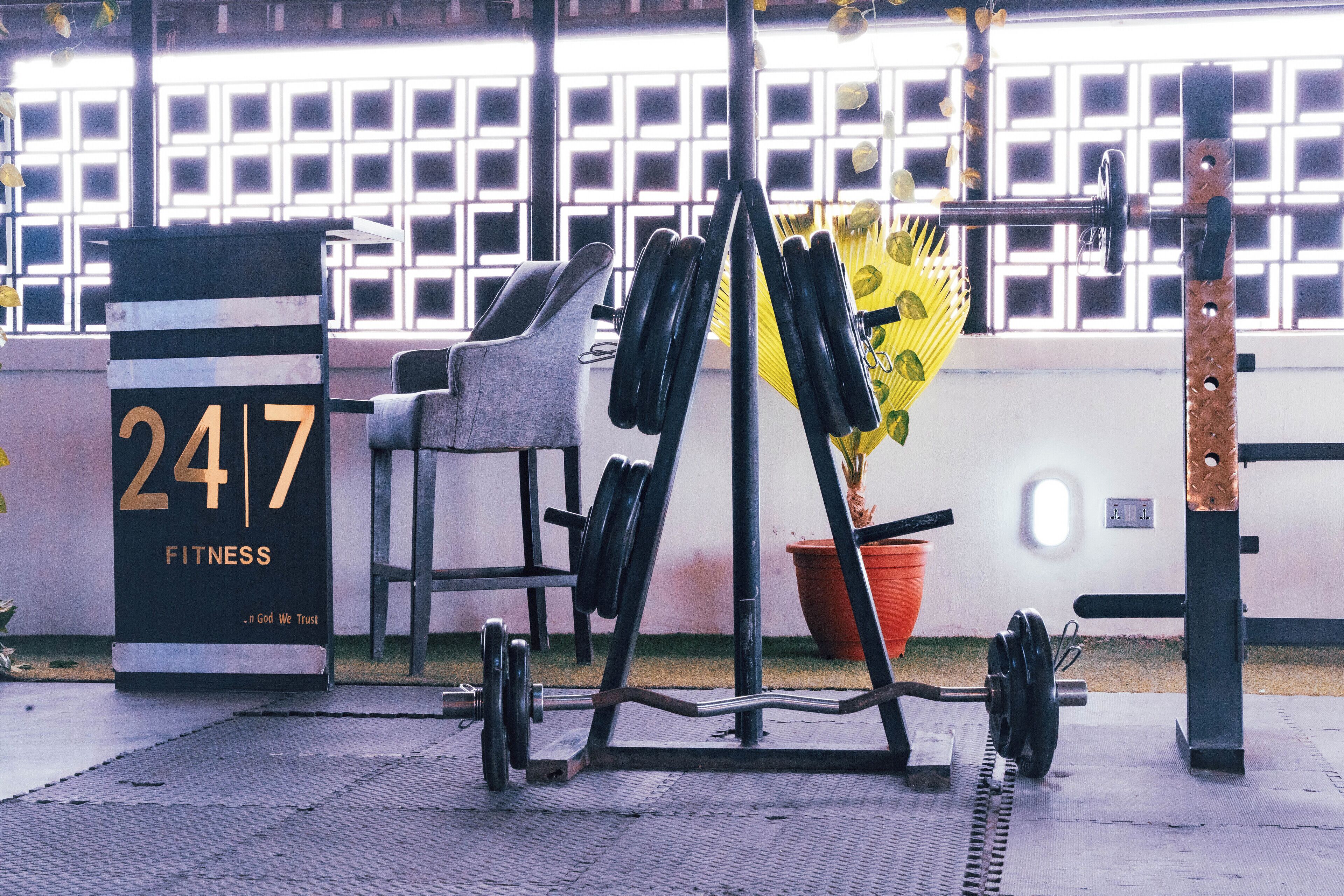 A gym with a weightlifting area, a bench, and a sign with the number 247.