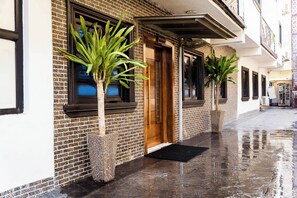 A building with a reception area, a wooden door, and a black awning. - 247 Luxury Apartment (Lekki)
