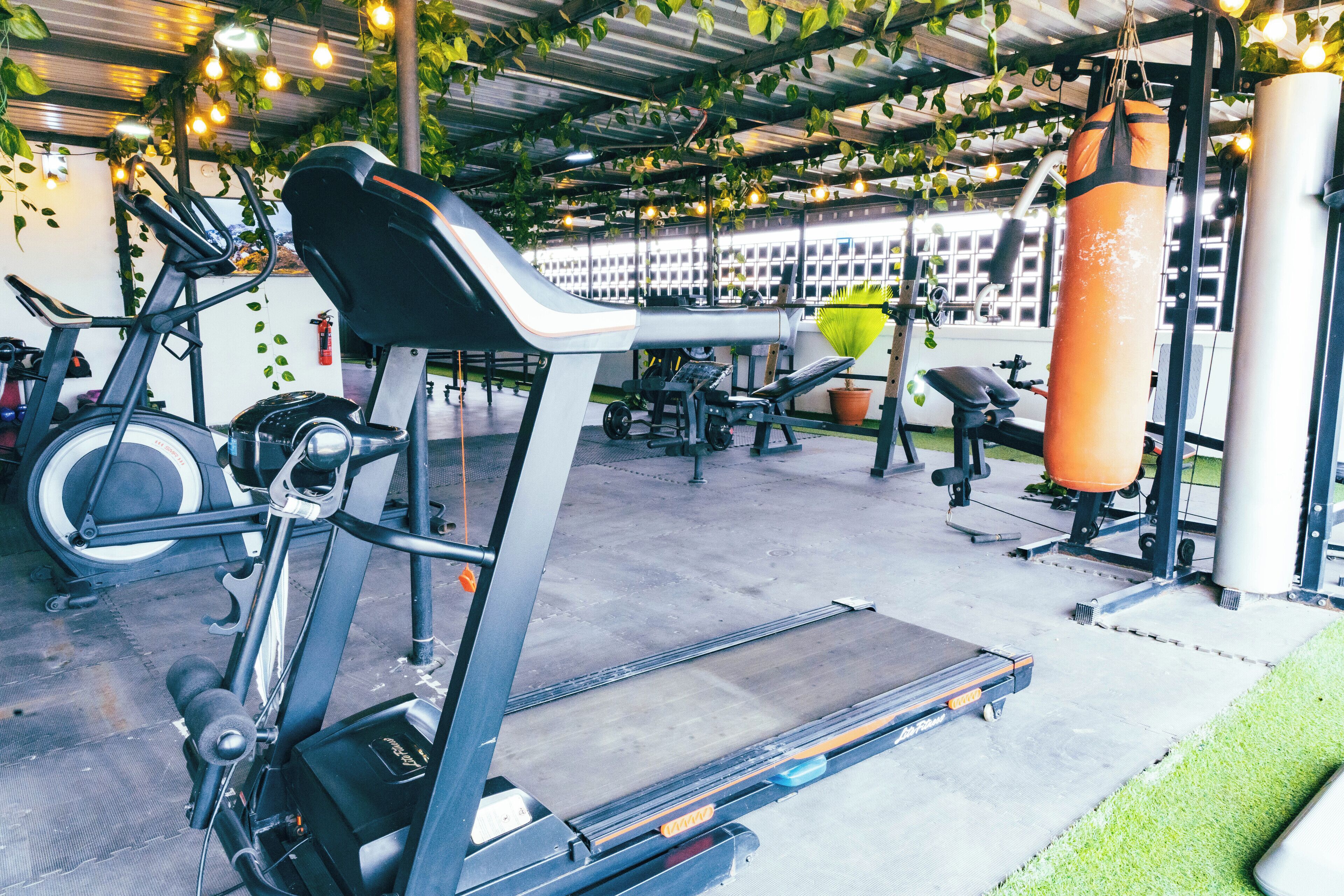 A gym with exercise equipment, including a treadmill, stationary bike, and punching bag.
