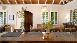 Un comedor con una mesa de madera, sillas y una araña.