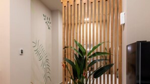 Una cocina moderna con un separador de madera, un refrigerador y una planta en maceta.