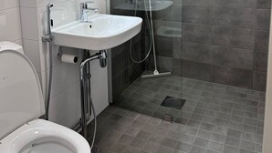 Un baño moderno con inodoro, lavamanos y ducha.